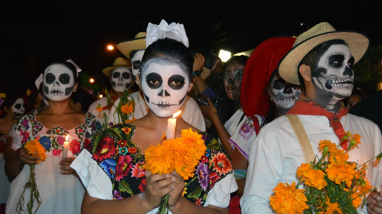 Optog med udklædte mennesker, blæser-orkestre og glade mexicanere markerer de døde sjæle med en hyldest til livet.
