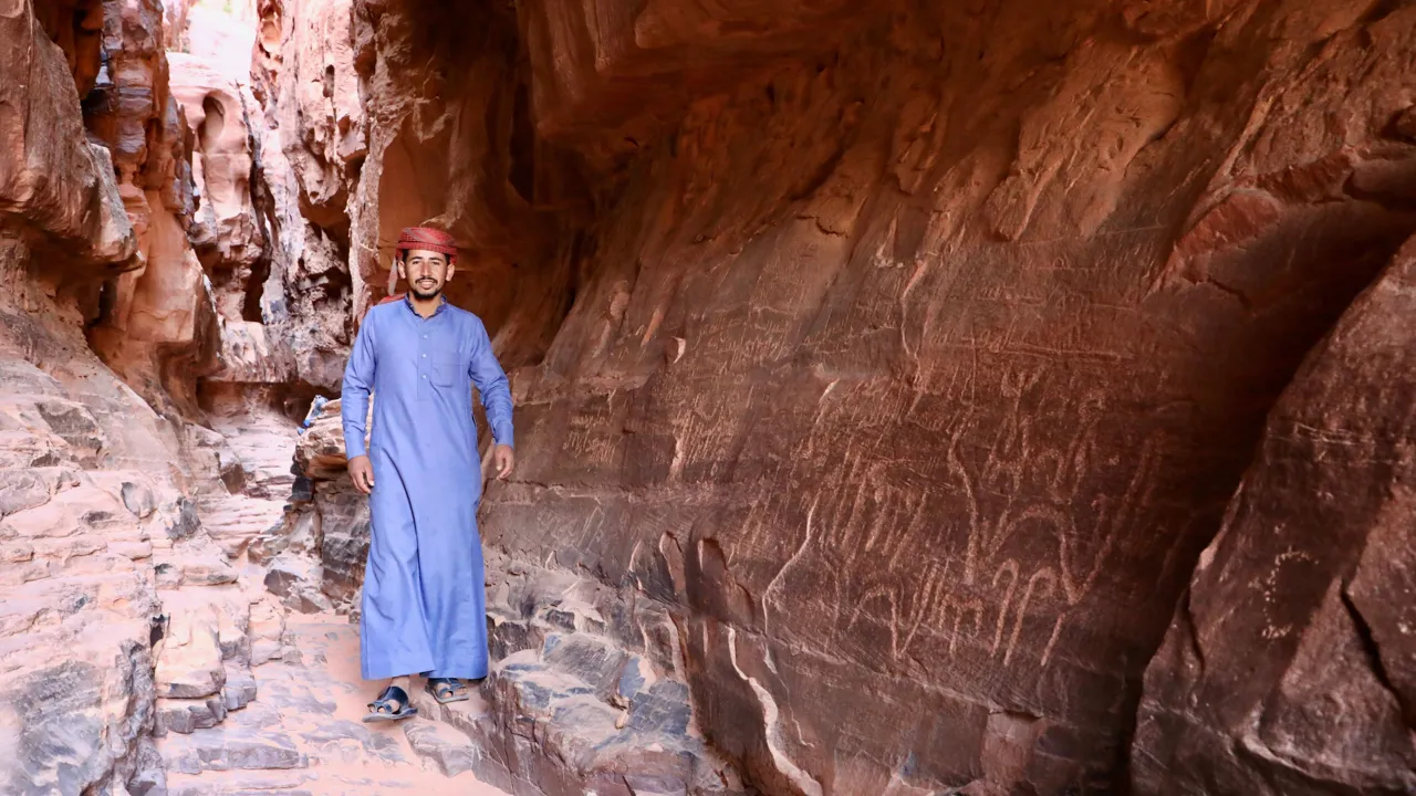 Bedouin viser urgamle klippekunst i en skjult kløft i Wadi Rum. Foto Anders Stoustrup