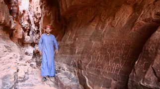 Bedouin viser urgamle klippekunst i en skjult kløft i Wadi Rum. Foto Anders Stoustrup