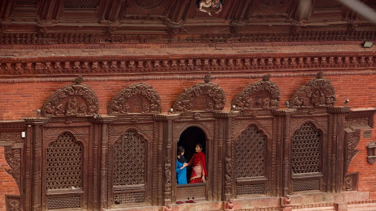 Et par kvinder får sig en snak i en af de gamle bygninger på durbar pladsen i Kathmandu. Foto af Anders Stoustrup