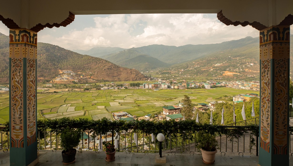 På Bhutan Mandala Resort her mange værelser har udsigt over Paro-dalens marker omgivet af lave, skovklædte bjerge. 