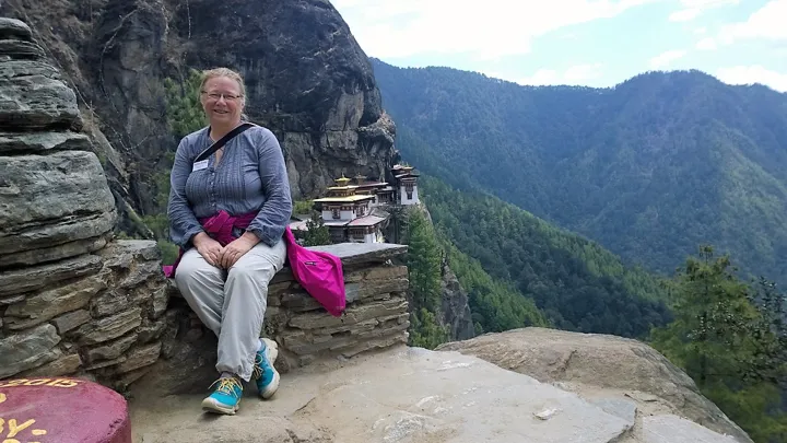 Viktors Farmor rejseleder Elisabeth Sandell poserer foran Tiger's Nest i Bhutan