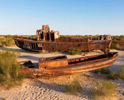 Skibe ligger røde af rust på den tørre havbund af Aralsøen.