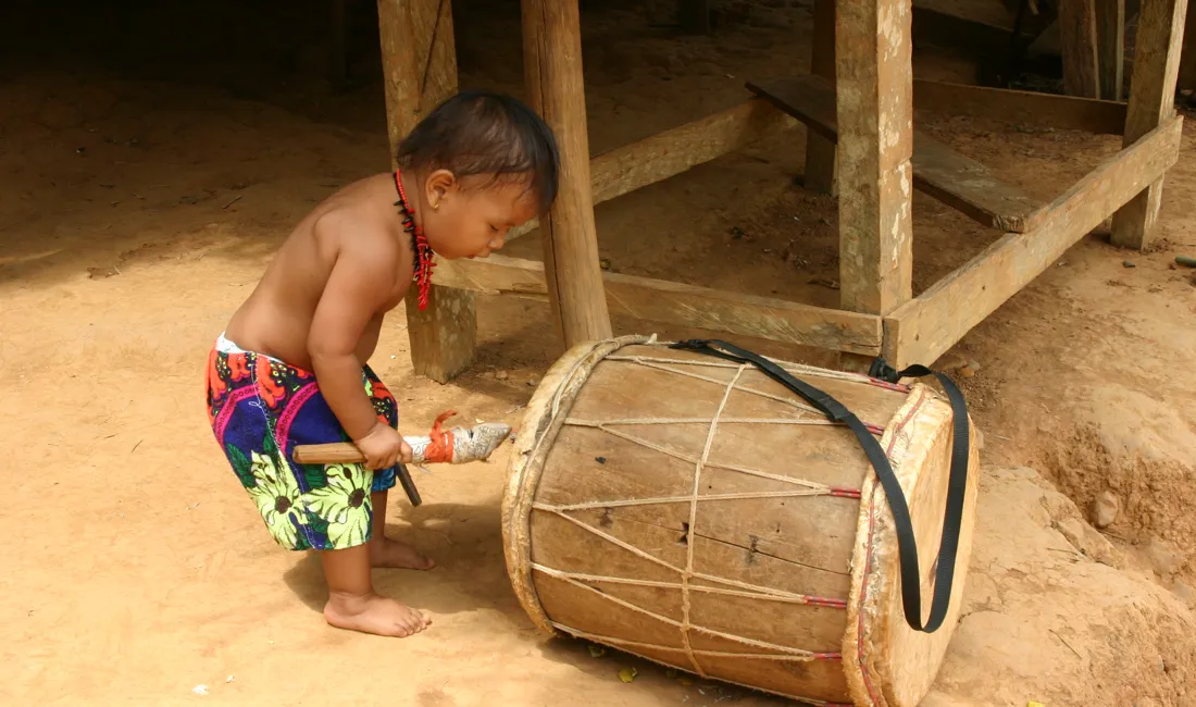 En lille indianer prøver en stor tromme i Panama. Foto Claus Bech