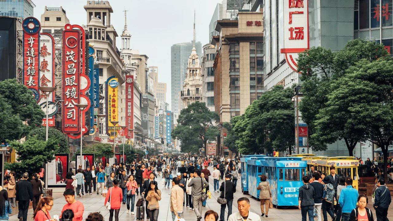 Shanghais livlige handelsstrøg, sporvogne og neonskilte. Foto Viktors Farmor