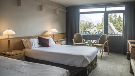 På en skråning over søen ligger dette hyggelige 3-stjernede hotel med klassiske A-formede chaletbygninger.