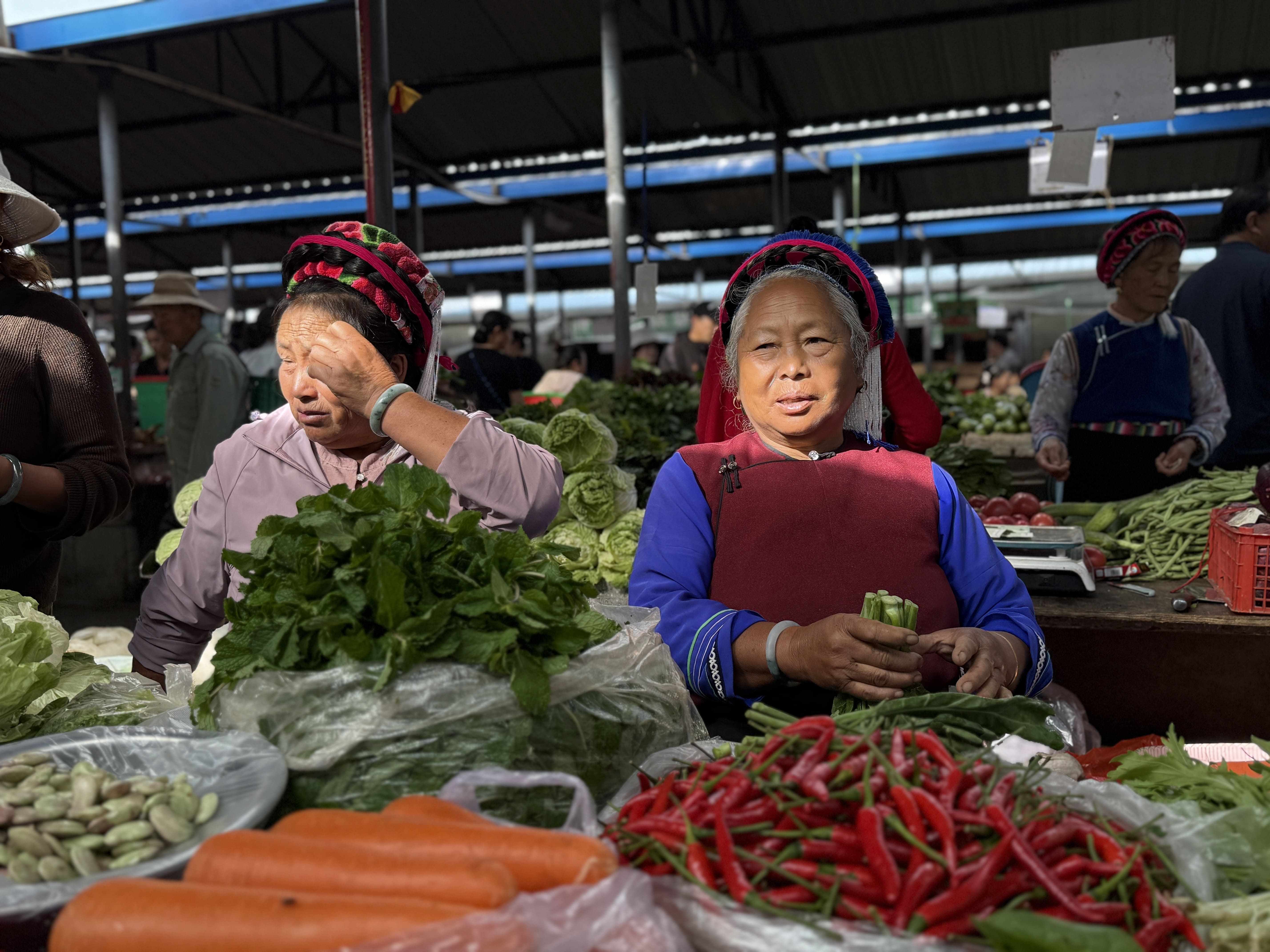 Kvinder i traditionelle dragter på lokalt grøntsagsmarked i Dali. Foto Signe Bjørnskov Mynster