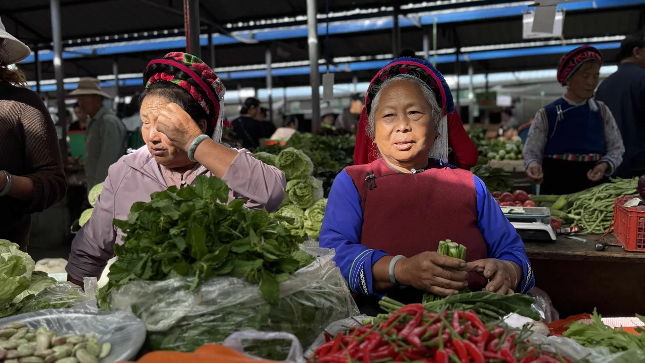 Kvinder i traditionelle dragter på lokalt grøntsagsmarked i Dali. Foto af Signe Bjørnskov Mynster