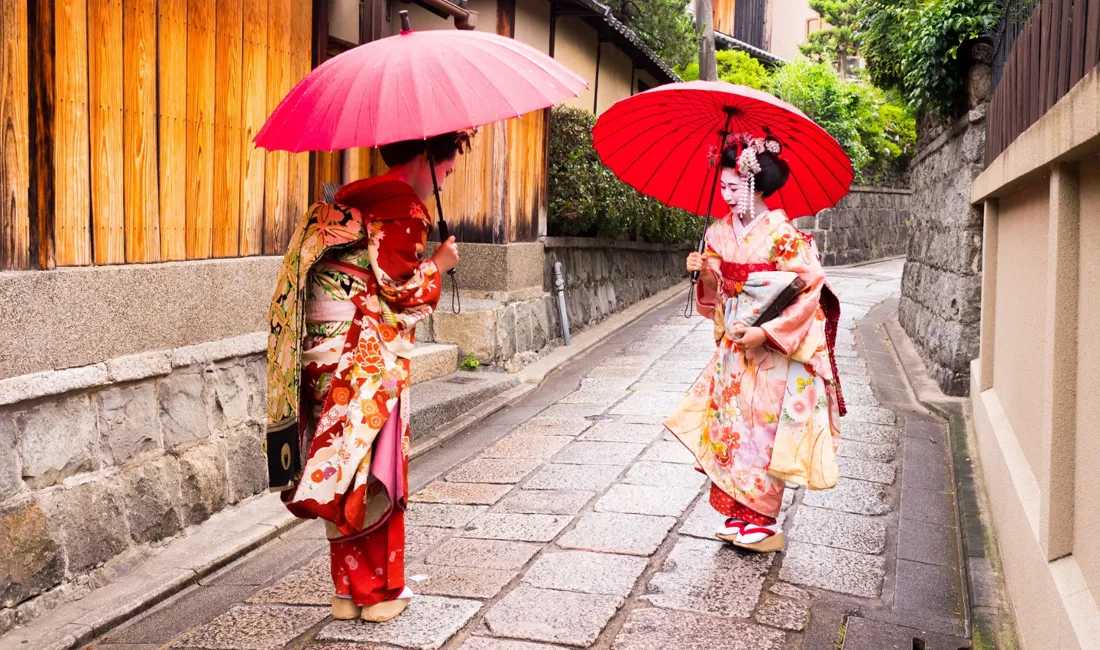 To maikoer på vej gennem Kyoto.