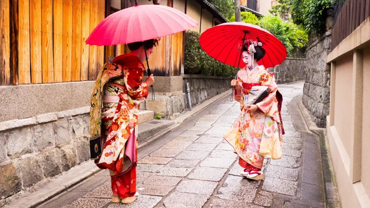 To maikoer på vej gennem Kyoto.