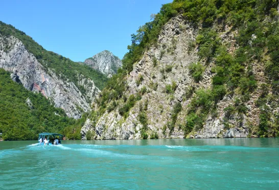 En rejse i Albanien hvor Koman søens turkisblå vand står i kontrast til omkringliggende klipper. Foto Viktors Farmor